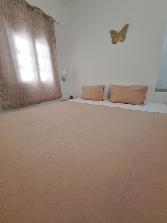a bedroom with a bed with a butterfly on the wall at Studios Irineos in Perissa