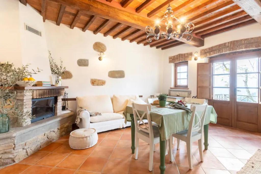 ein Wohnzimmer mit einem Tisch und einem Kamin in der Unterkunft Olive House Tuscany in Calci