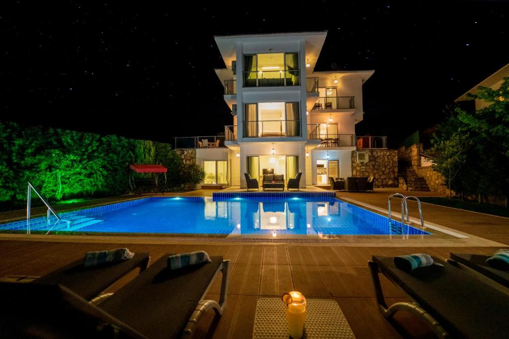 a house with a swimming pool in front of a building at Villa Fortuna Oludeniz , 5 Bedroom, Large Swimming Pool, Modern Design in Oludeniz