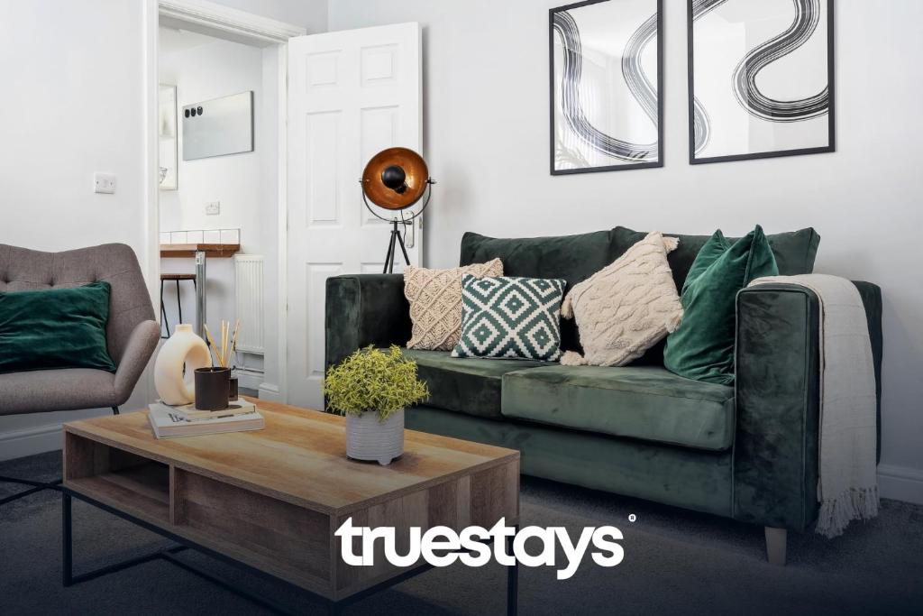 uma sala de estar com um sofá verde e uma mesa de centro em NEW Lime House by Truestays - 3 Bedroom House in Stoke-on-Trent em Stoke-on-Trent