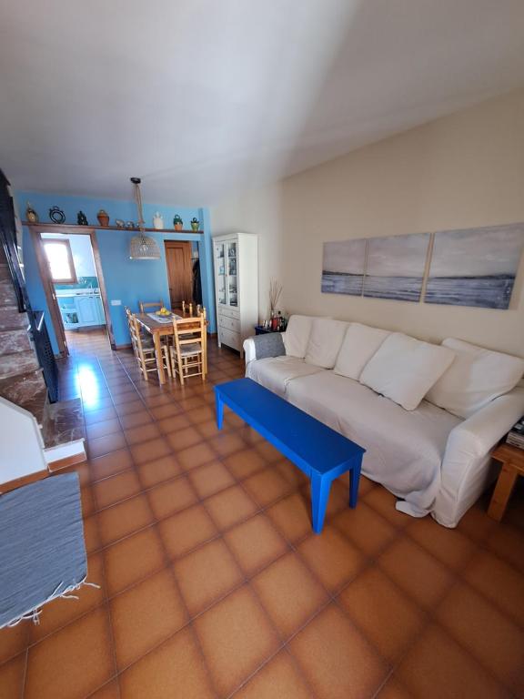 een woonkamer met een bank en een tafel bij Casa apareada cerca de la playa in Torredembarra