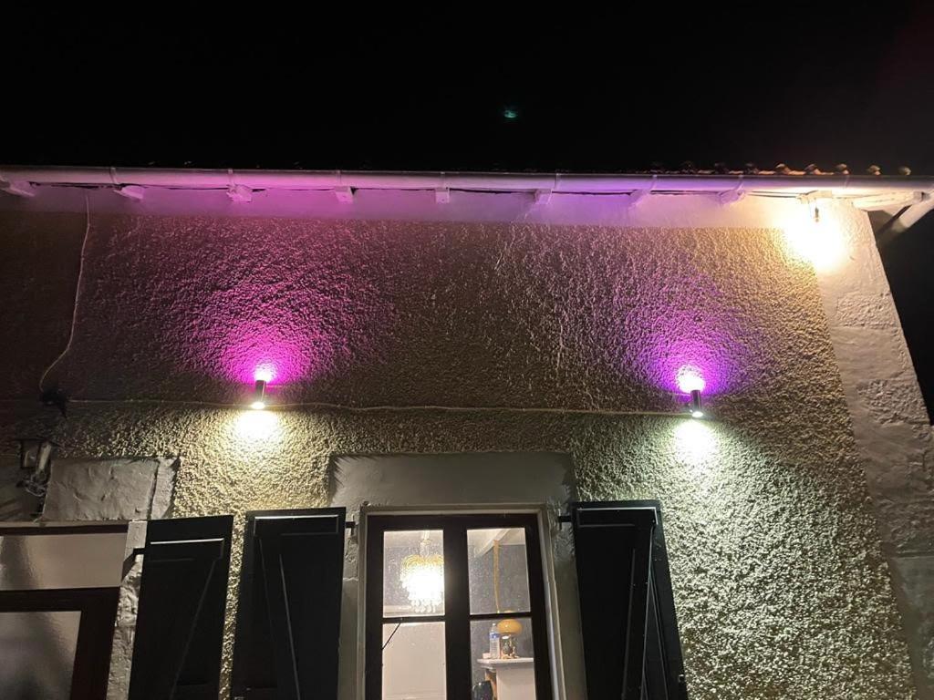 two purple lights on the side of a building at Chateau Mano in Mairé-lʼEveseault