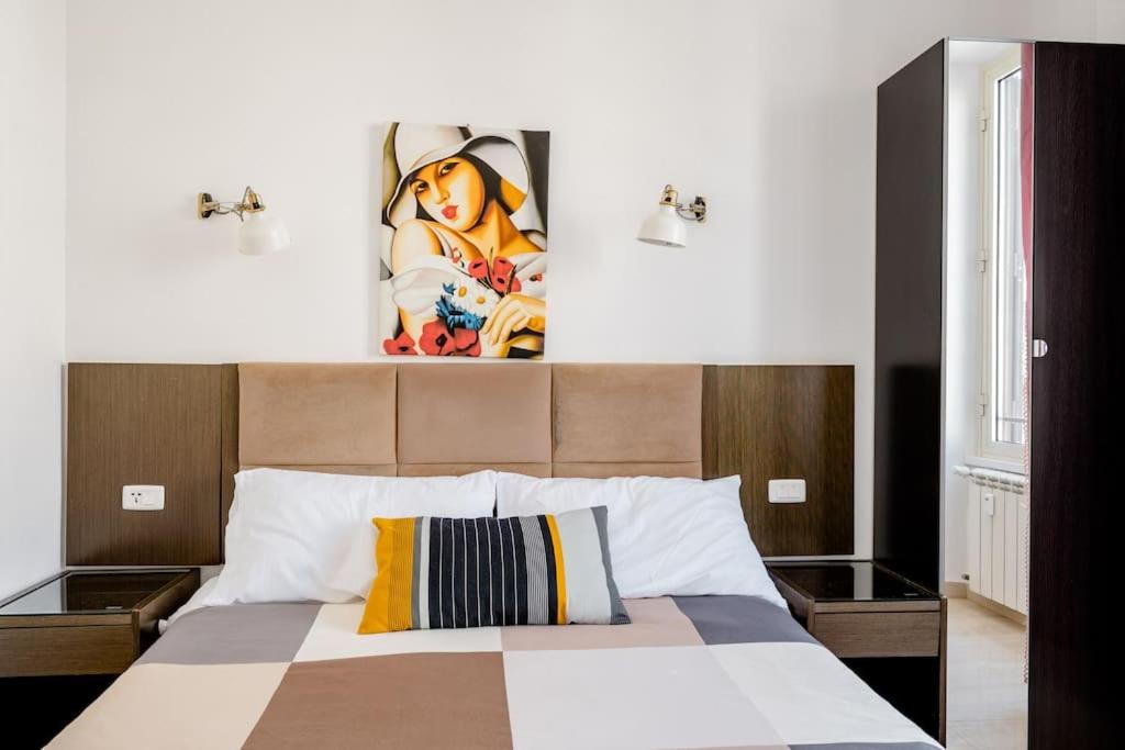 a bedroom with a large bed with a painting on the wall at Francesco Romestay - Termini in Rome