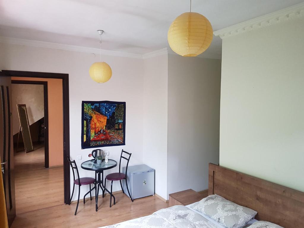 1 dormitorio con mesa, sillas y 1 cama en LA CASA, en Tiflis