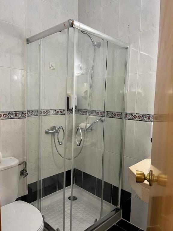 a glass shower in a bathroom with a toilet at Real Caparica Hotel in Costa da Caparica