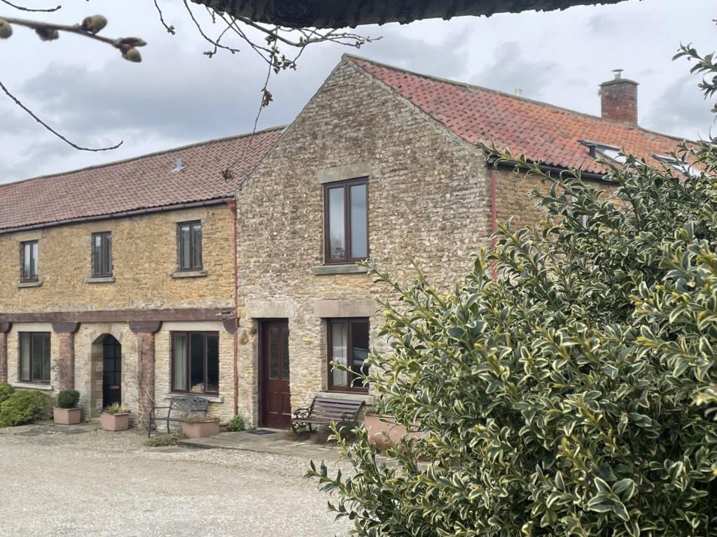 ein altes Backsteinhaus mit einer Bank davor in der Unterkunft Harvest End in York