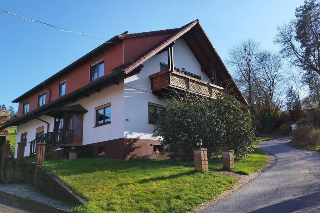 una casa con un balcón en el lateral. en Ferienwohnung Schmidt, en Airlenbach