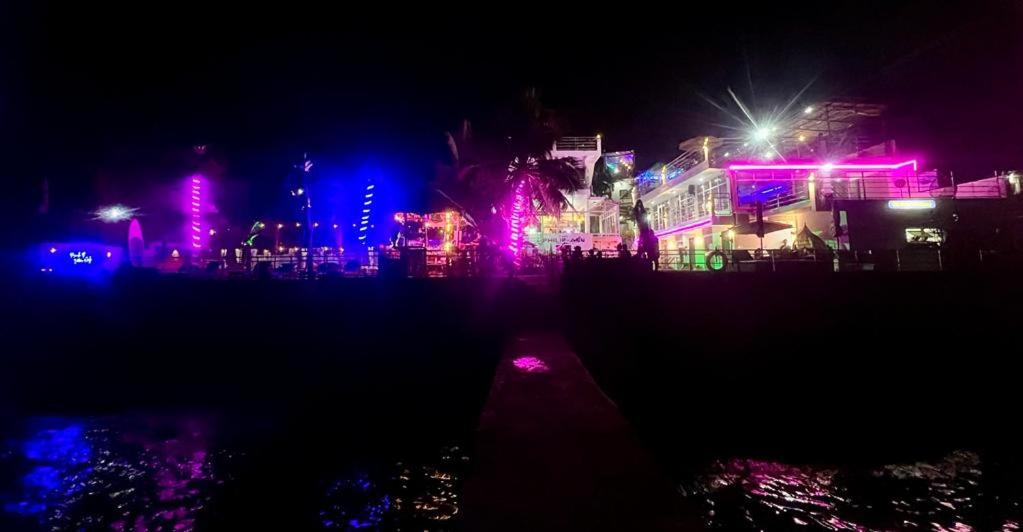 a city lit up at night with pink and purple lights at The Philip Ann Resort in Mabini