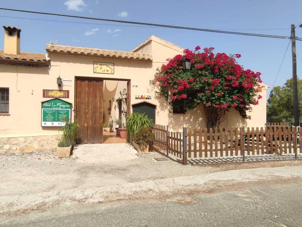 ein Gebäude mit einem Zaun und Blumen darauf in der Unterkunft Hotel La Mariposa in Alhama de Murcia