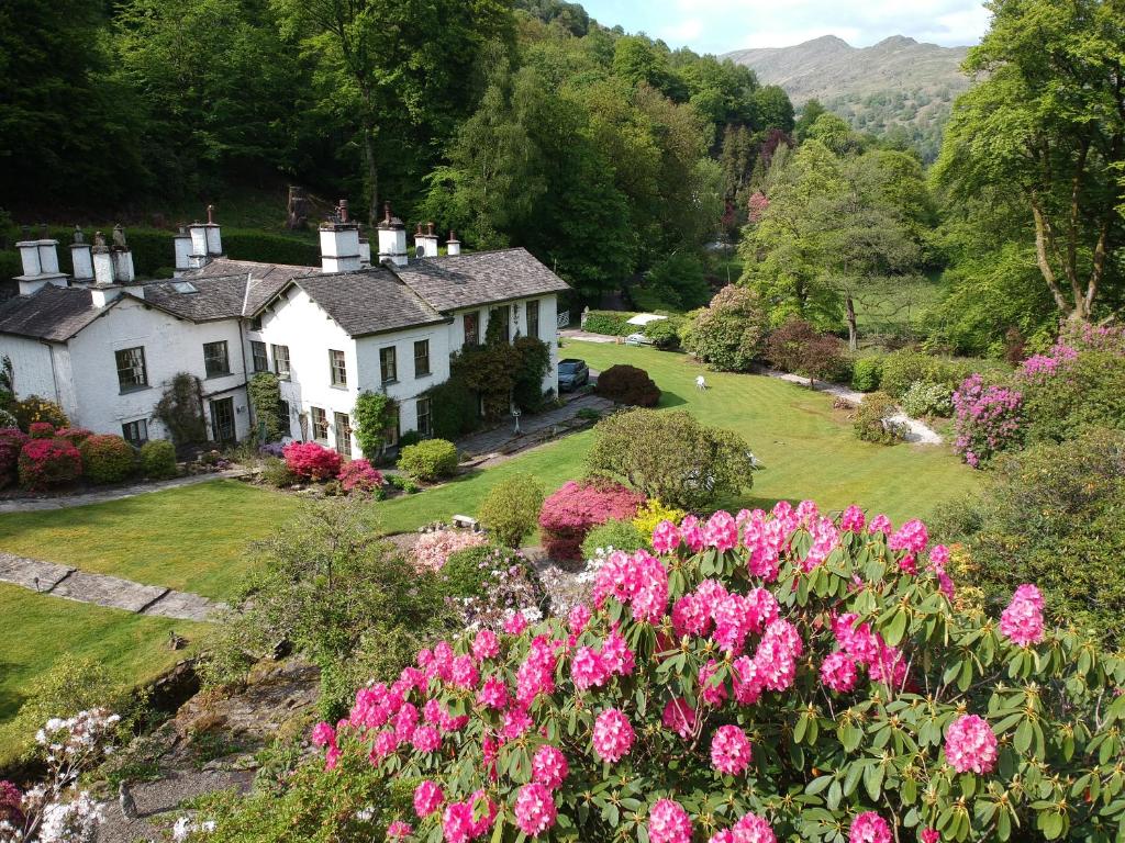 una casa en un jardín con flores rosas en Foxghyll Country House en Ambleside