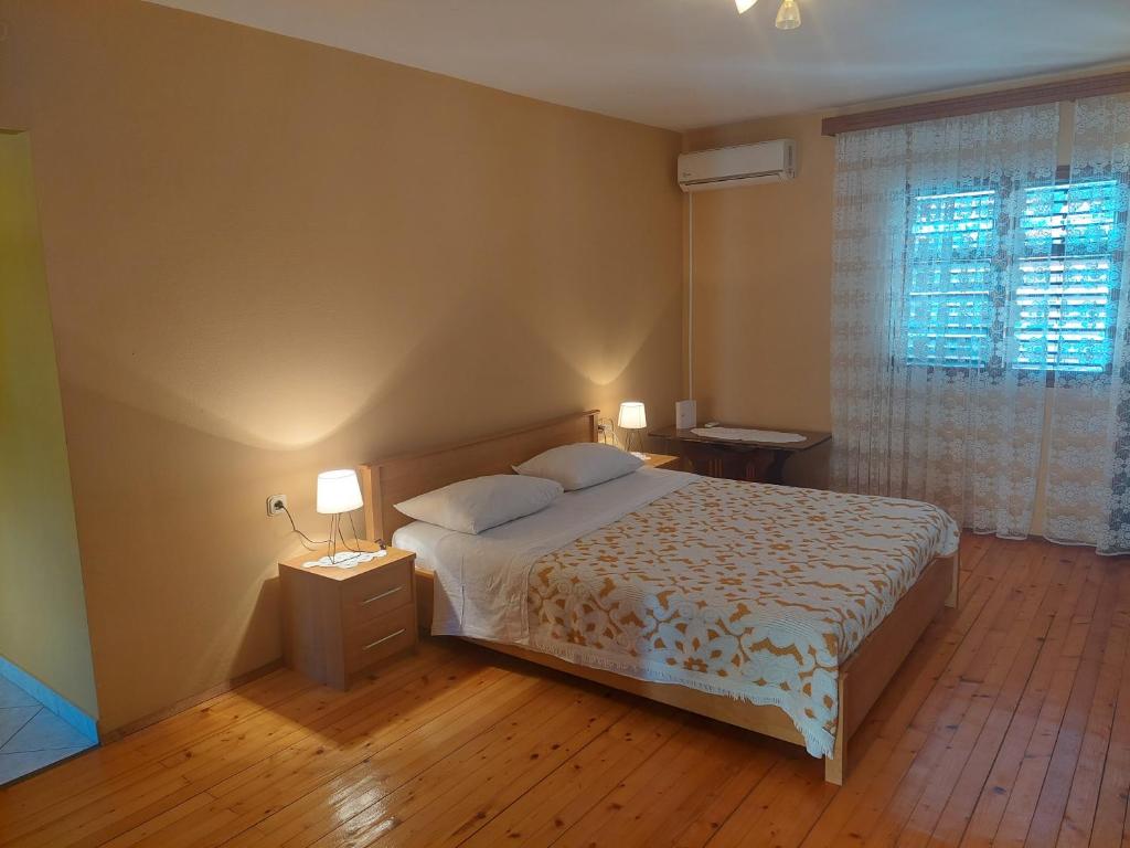 Private Beach Apartment and rooms في برنا: غرفة نوم بسرير ومصباحين ونافذة