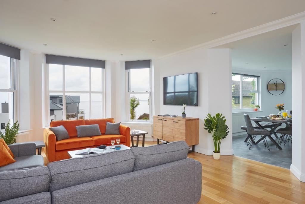 a living room with two couches and a tv at Shanklin Villa Aparthotel in Shanklin