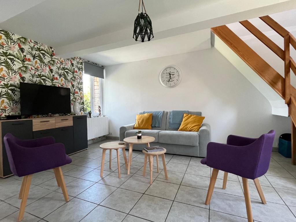 a living room with a couch and a table and chairs at L'hippo-gîte in Fressenneville