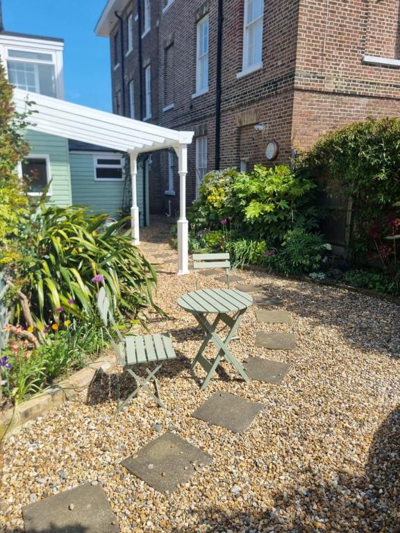 a picnic table and a bench in a garden at The Coach House- Stunning Detached Coastal home, with parking, by Historic Deal Castle in Deal