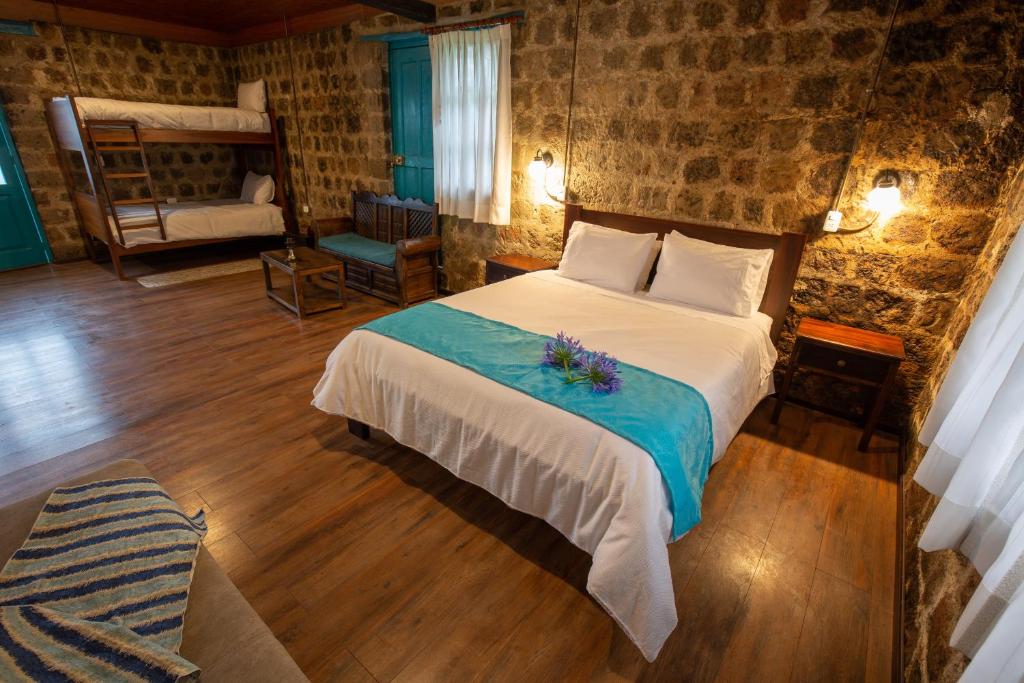 a bedroom with a large bed with flowers on it at Niebli Historical Farm and Lodge at Pululahua Volcano in Quito