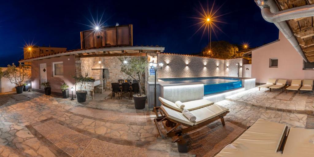 a villa with a swimming pool at night at Apartment Anitea in Pula