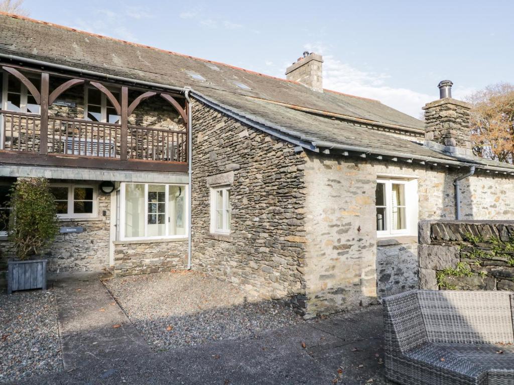 an old stone house with a balcony on it at Bassicks at the Graythwaite Estate in Ulverston