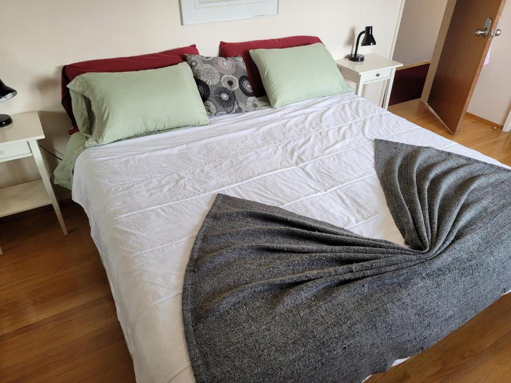 a large bed with a blanket on it in a bedroom at The Dewberry Homestay B&B in Edmonton