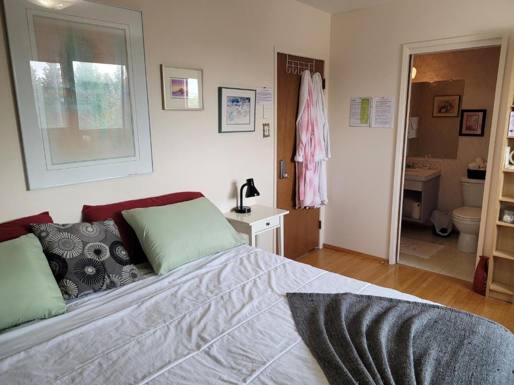 a bedroom with a bed and a bathroom with a toilet at The Dewberry Homestay B&B in Edmonton