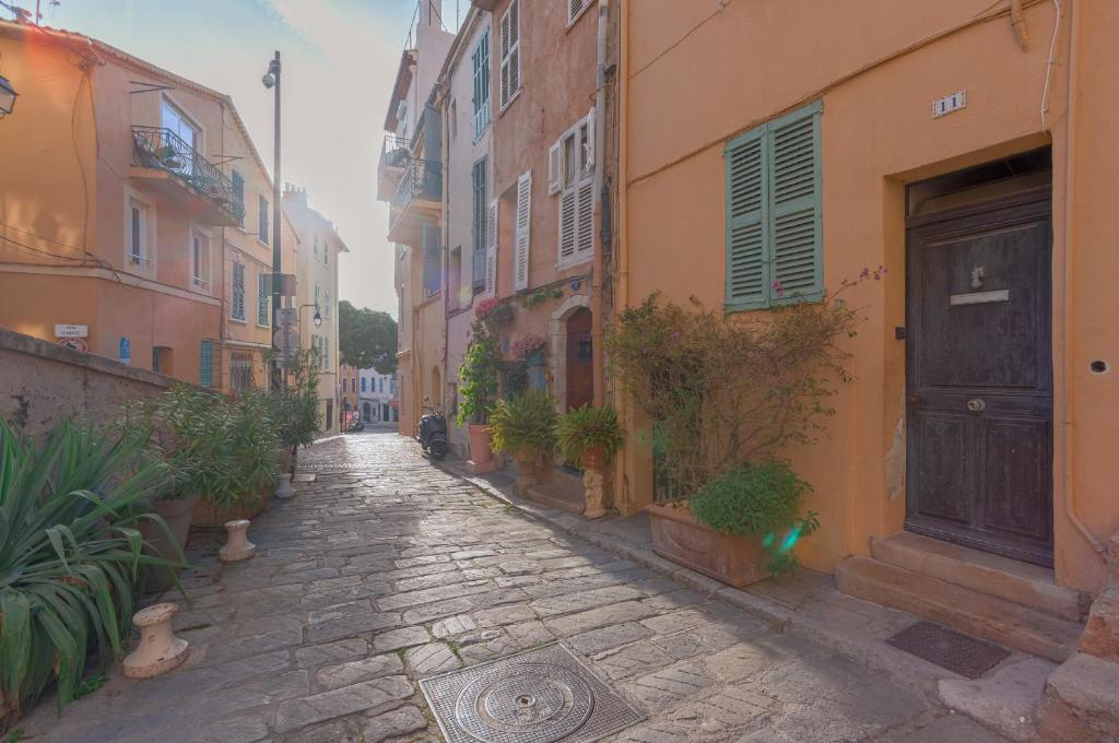 an alley with buildings and a door and potted plants at Un Écrin au Suquet - Studio, clim, balcon, plage, Palais des Festivals in Cannes