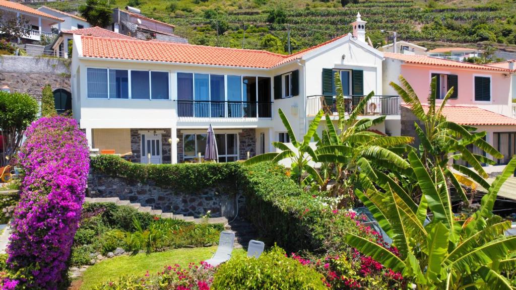 a house with flowers in front of it at Bohome Nest by LovelyStay in Arco da Calheta