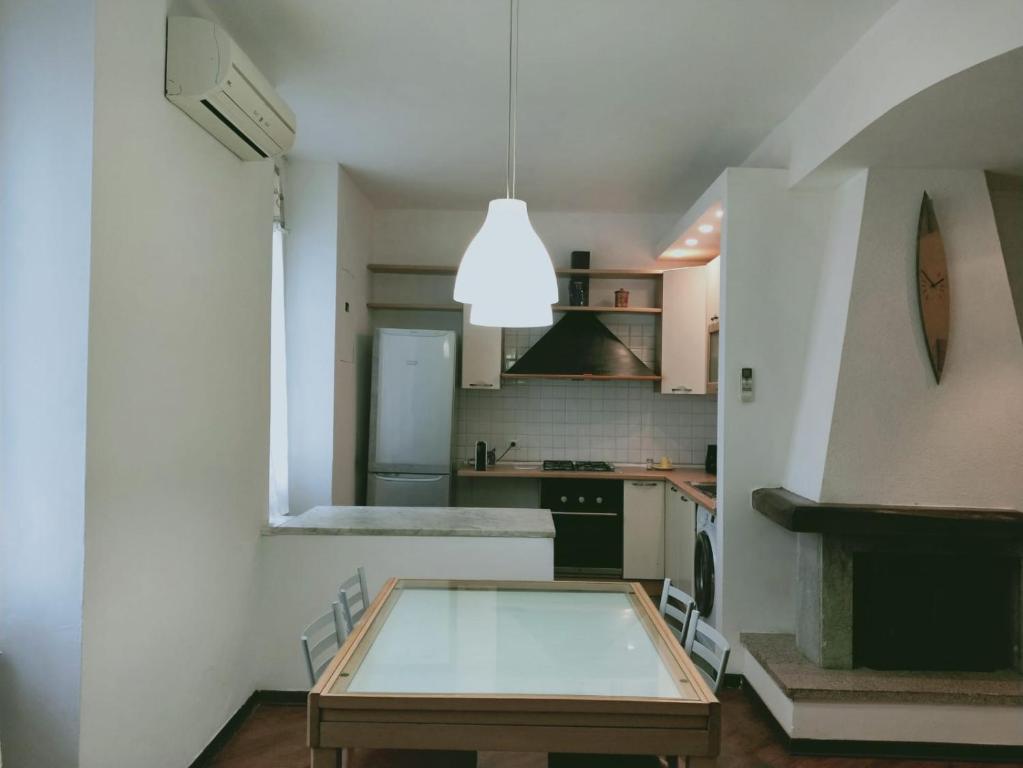 una cocina con una mesa de cristal en el medio. en Casa Giulia La Spezia, en La Spezia