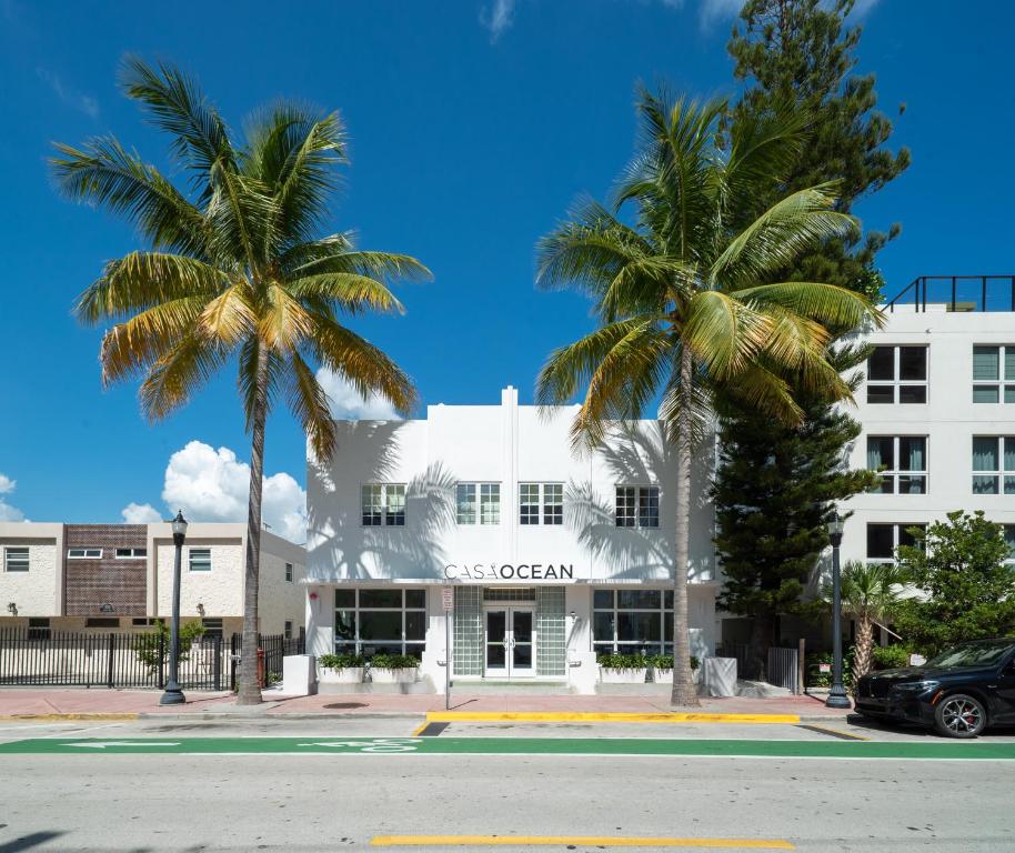 a white building with palm trees in front of it at Casa Ocean in Miami Beach