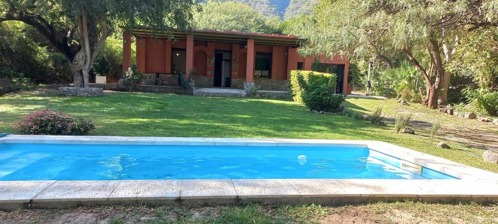 a swimming pool in front of a house at TADASANA CASA DE CAMPO in La Carrera