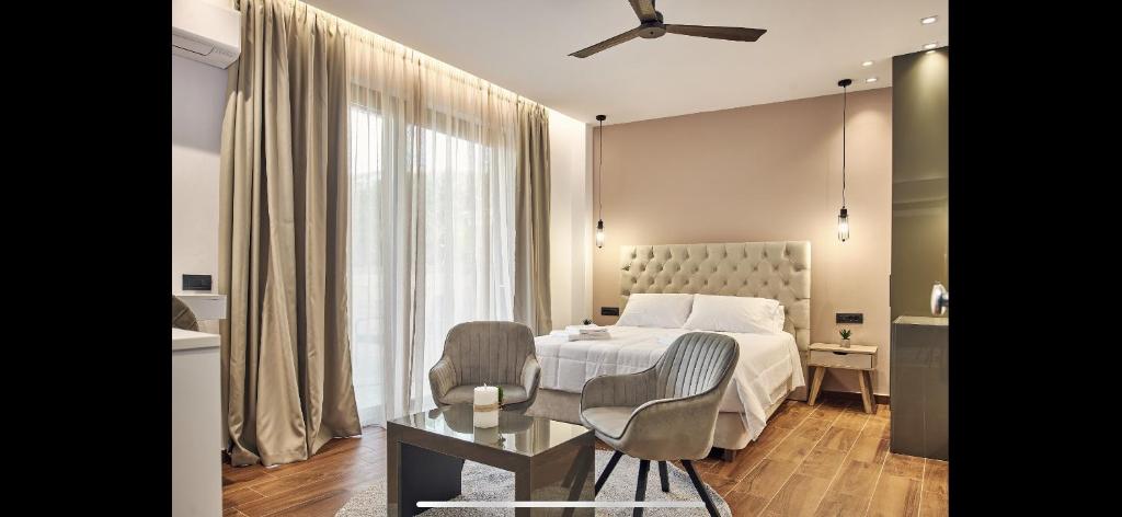 a bedroom with a bed and a table and a chair at Amuse Luxury Apartments in Zakynthos