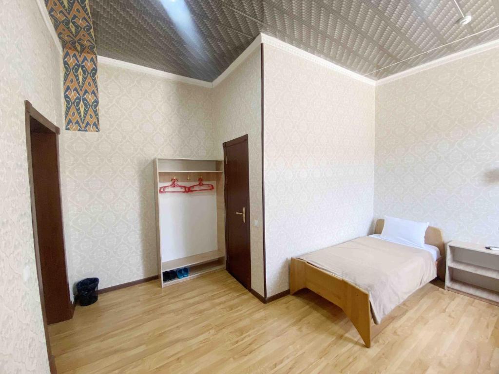 ヒヴァにあるPolvon Ota Hotelのベッド1台とシンクが備わる客室です。