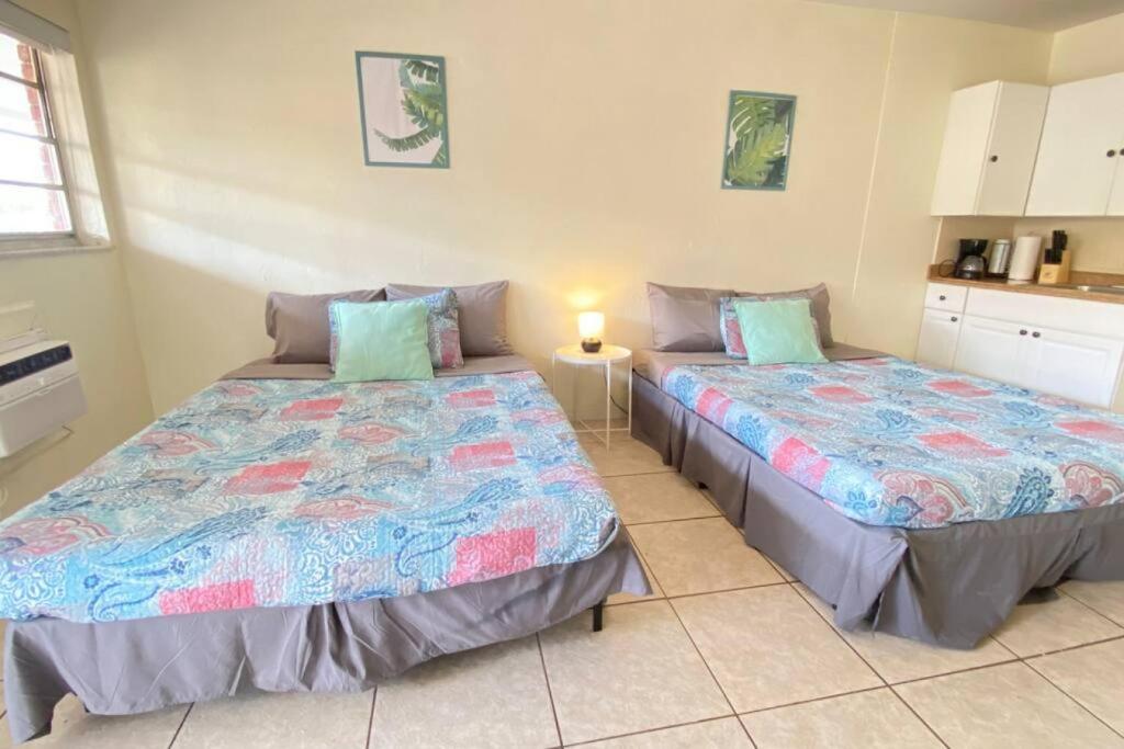 two beds in a room with a kitchen at Blissful Studio in Hallandale Beach 8mins to beach in Hallandale Beach