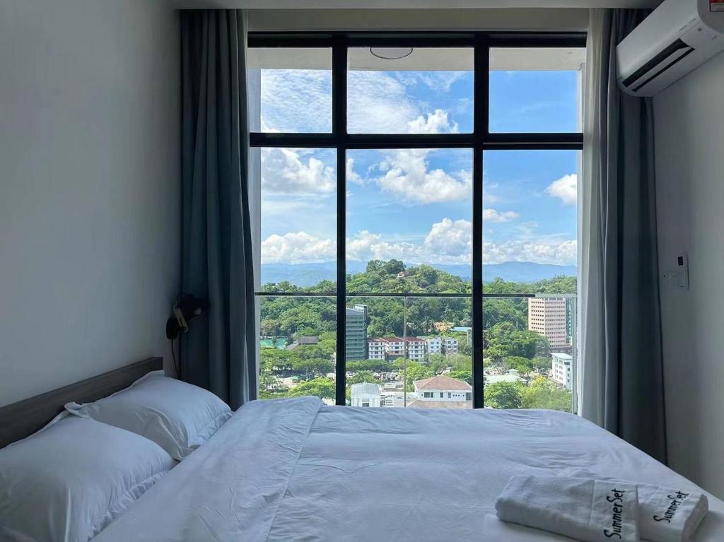 a bed in a room with a large window at Summer Studio Apartment at Kota Kinabalu City Centre in Kota Kinabalu