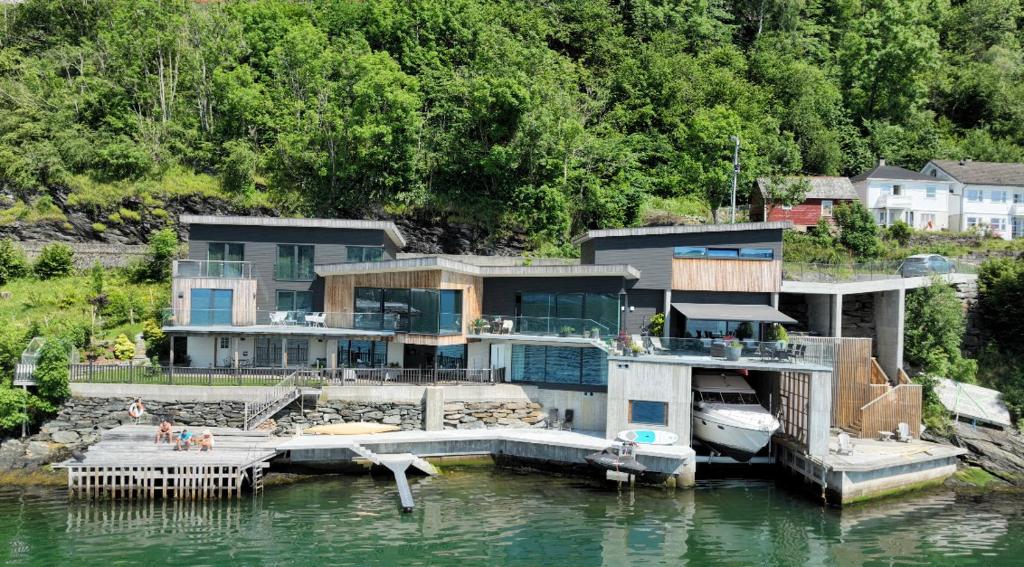 a large house on the water with a dock at Panoramaresort in Hardangerfjorden With boat to rent - leilighet i sjøkanten ved Hardangerfjorden for 7 personer NEW sauna from desember 2023 in Øystese