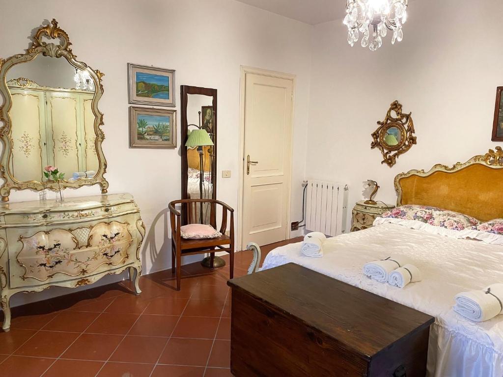 um quarto com uma cama, um espelho e uma cadeira em 'Il Casale di Giova' Tuscan Farmhouse em Lucca