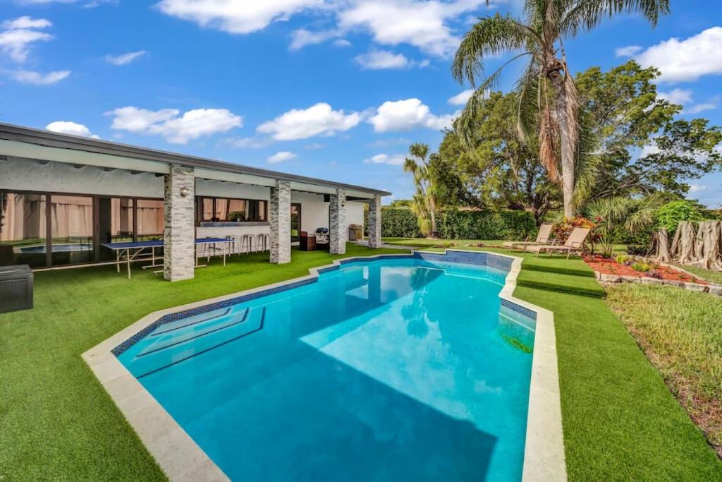 a swimming pool in the yard of a house at Modern Lux Pool Home Upscale, Spacious and Comfy in Kendall