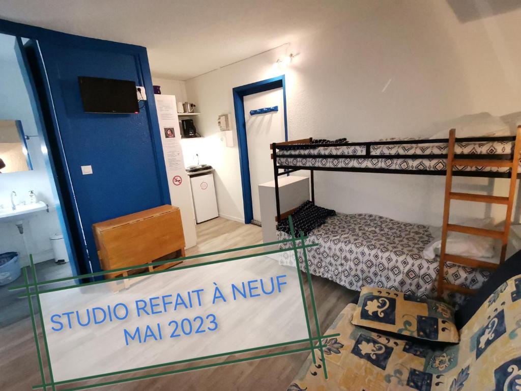 een kamer met stapelbedden en een bord dat saysstudio een newaan verhuurt bij STUDIO LES GLOVETTES in Villard-de-Lans