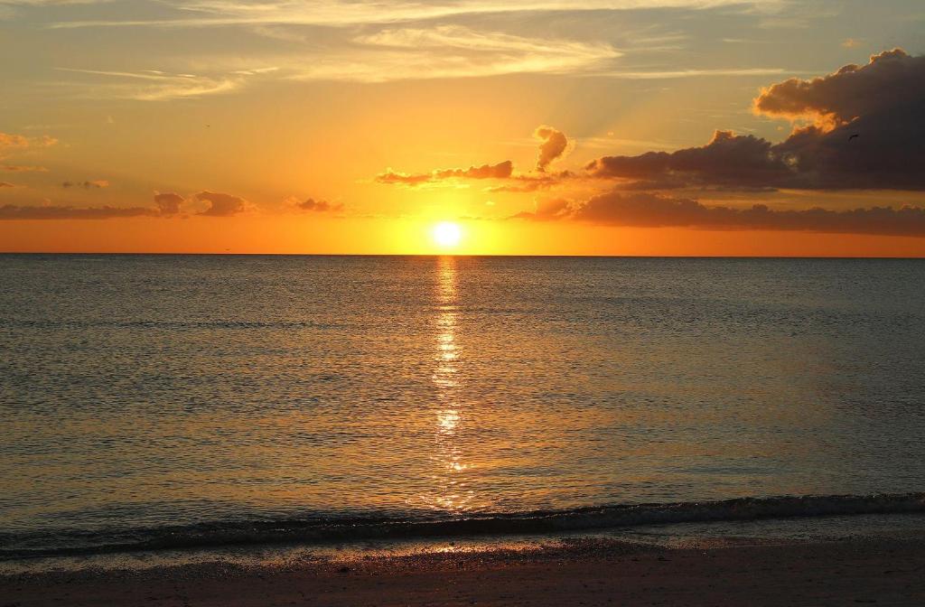 un tramonto sulla spiaggia con il tramonto di Vista Mar a St Pete Beach