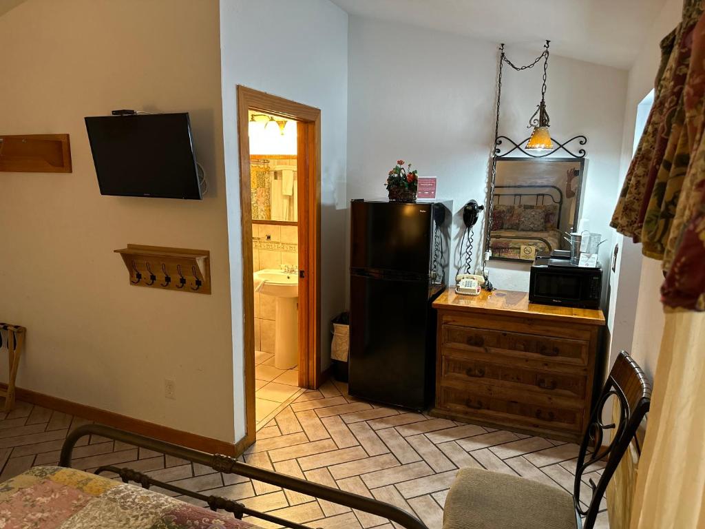 a kitchen with a black refrigerator and a counter at Buffalo Chip's Ranch House Motel in Bonita Springs