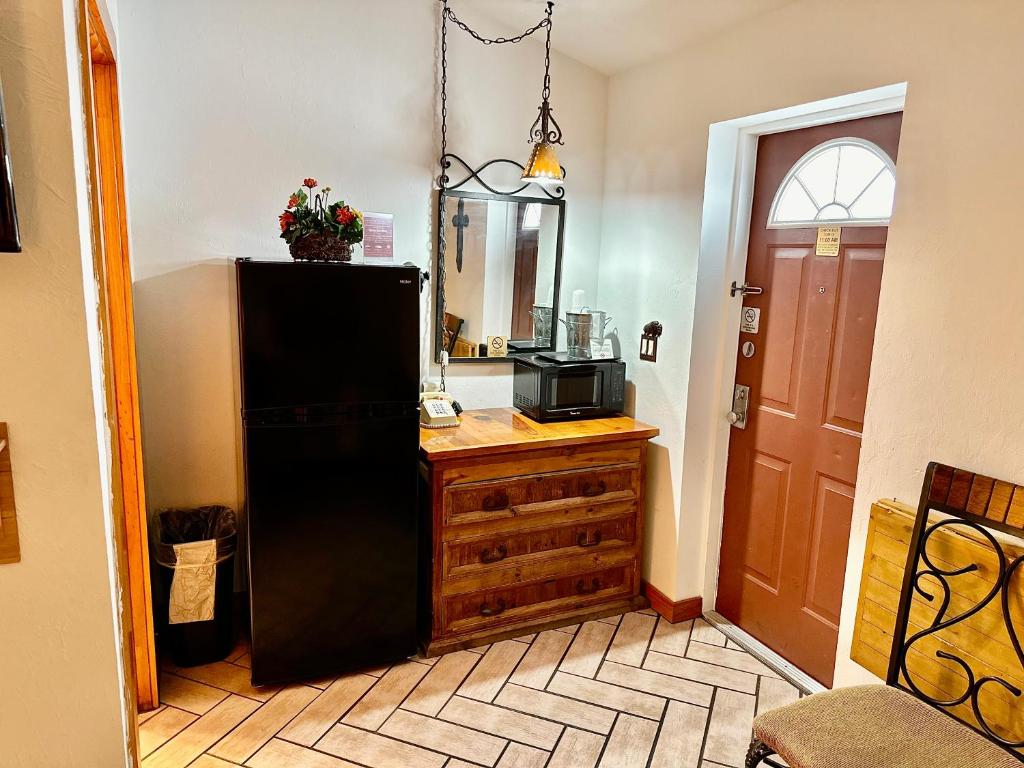 a kitchen with a black refrigerator and a wooden dresser at Buffalo Chip's Ranch House Motel in Bonita Springs