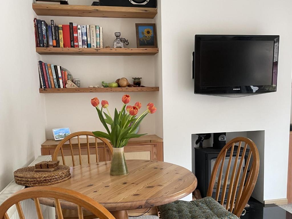 einen Esstisch und Stühle mit einer Blumenvase in der Unterkunft Glyn House by Cliftonvalley Apartments in Bristol
