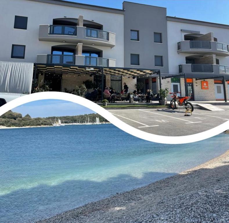 a building with a pool of water in front of it at Apartment Sandy Beach - 1st row at sea in Pješčana Uvala 