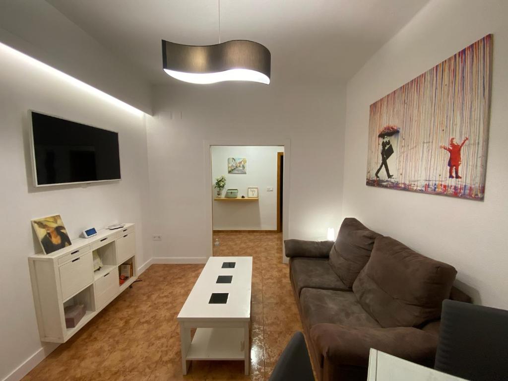 ein Wohnzimmer mit einem Sofa und einem Tisch in der Unterkunft COSTASOL CORDOBA - Apartamento moderno - céntrico in Córdoba