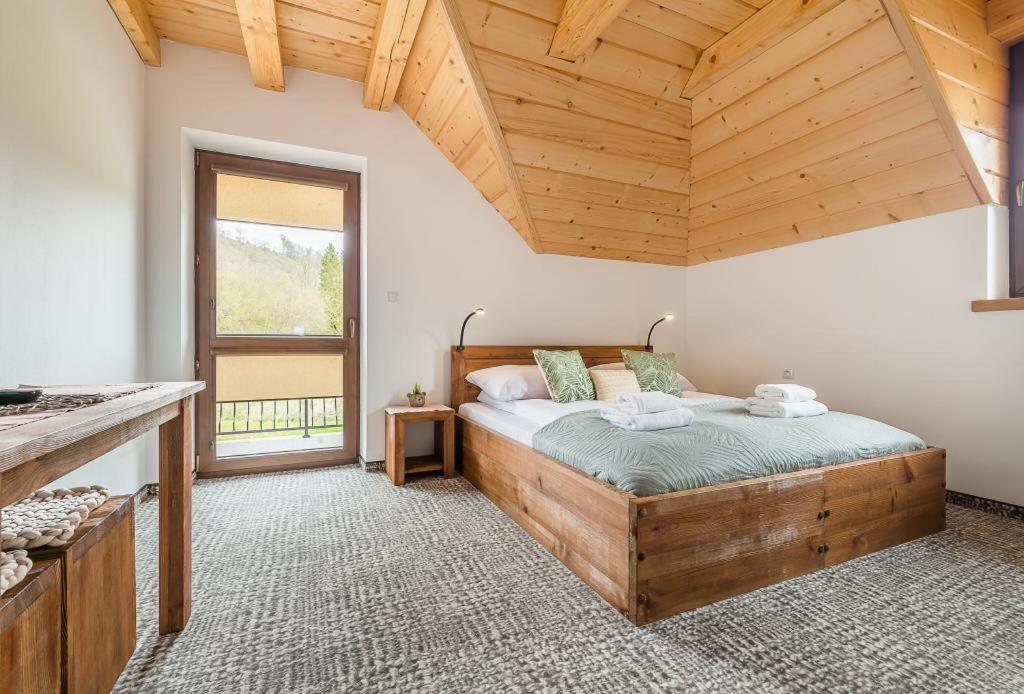 sypialnia z łóżkiem i drewnianym sufitem w obiekcie Smerek 119- Baza Przy Szlaku w Smereku
