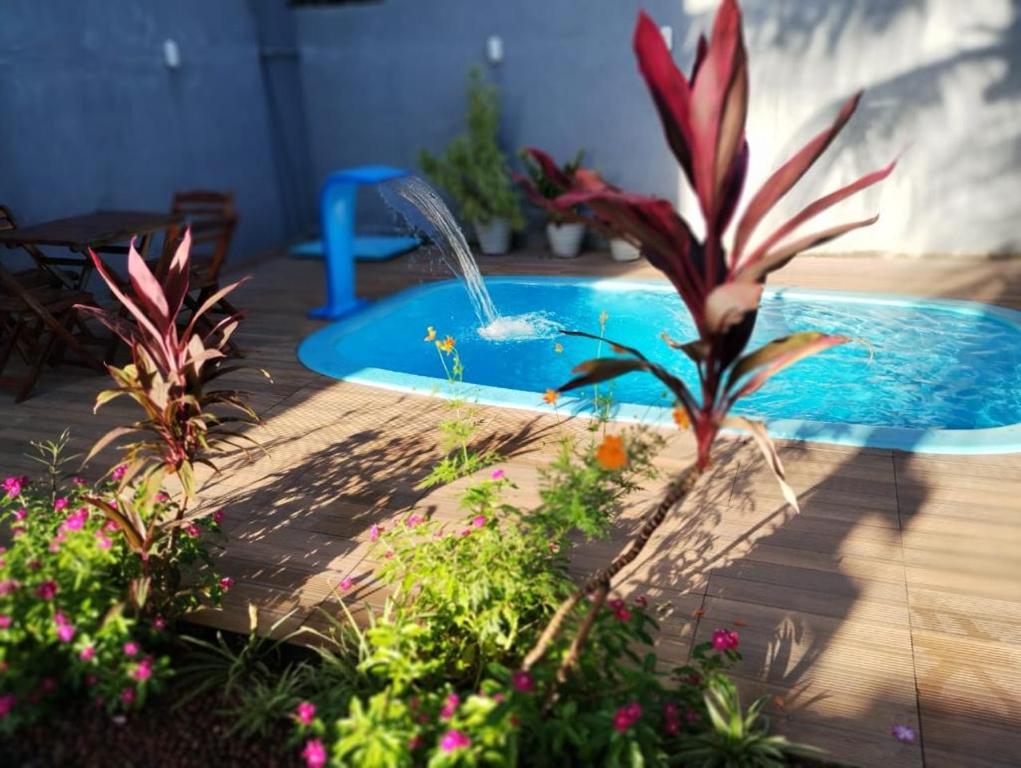 einen Pool mit einem Brunnen im Garten in der Unterkunft Chalé Aconchego 