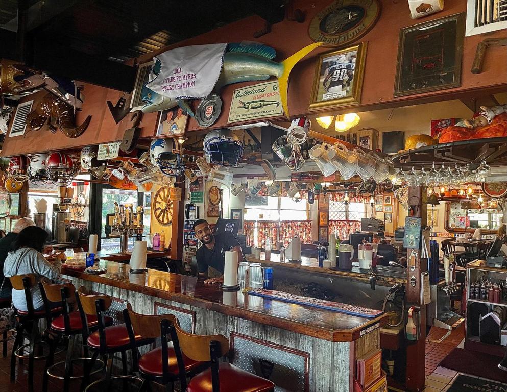 a bar with a man sitting at a counter at Buffalo Chip's Ranch House Motel in Bonita Springs