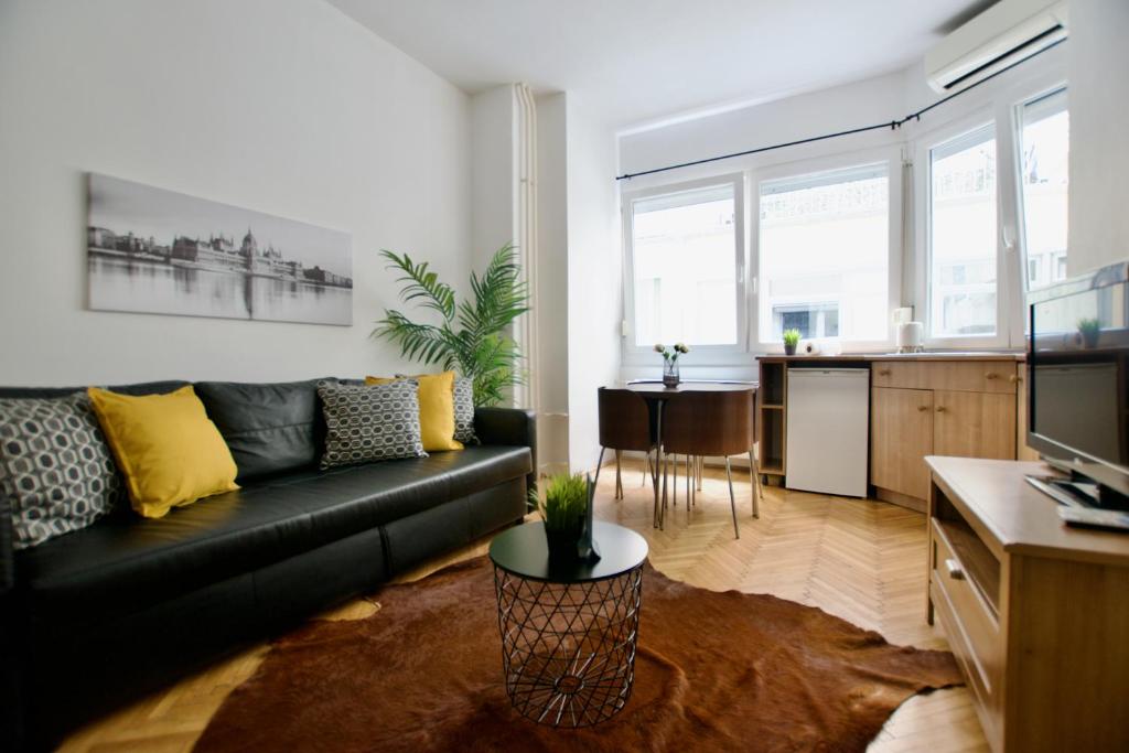 un soggiorno con divano nero e una cucina di Standard Apartment by Hi5 - Petőfi 12 a Budapest