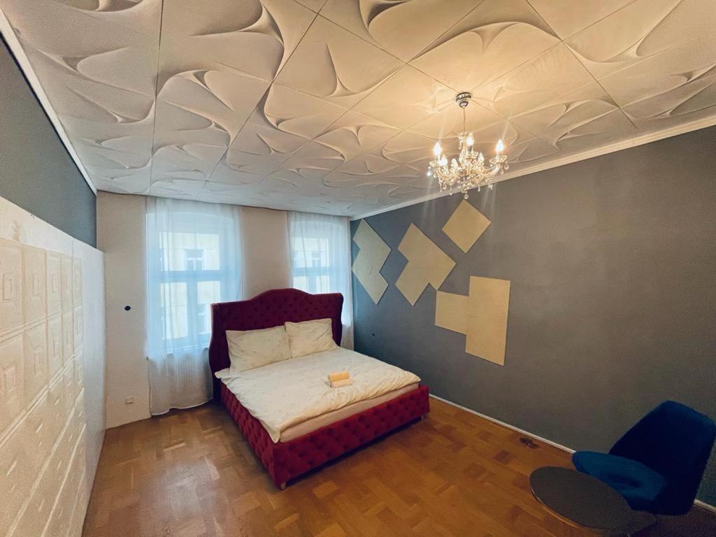 a bedroom with a bed and a ceiling with a chandelier at Sunrise Apartment in Vienna