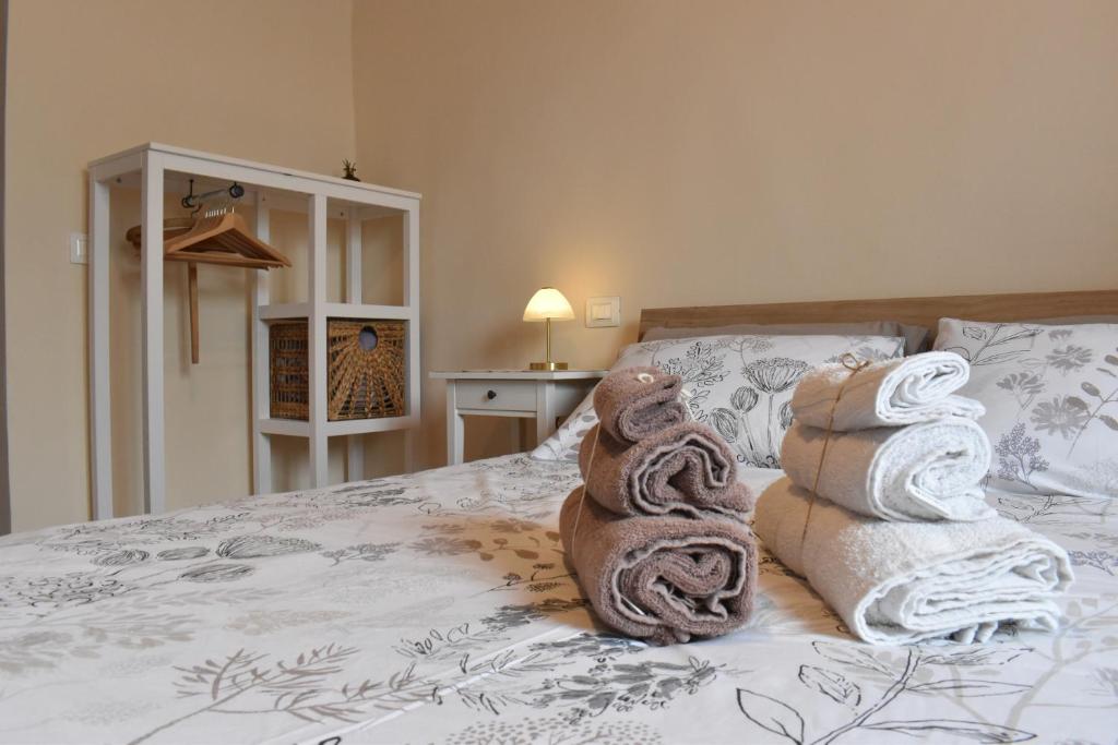 a bedroom with a bed with towels on it at Claves Claustri - Camere in appartamento storico in Sarteano