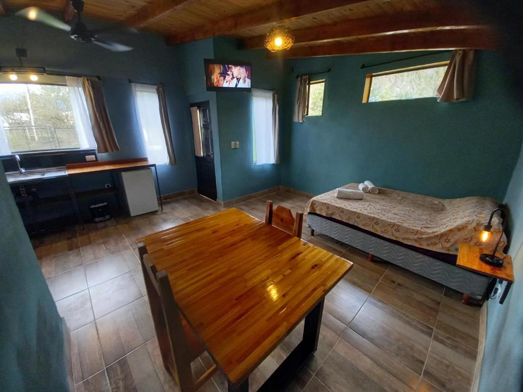 1 dormitorio con cama y mesa de madera en Departamento ElTrebol en Lago Puelo