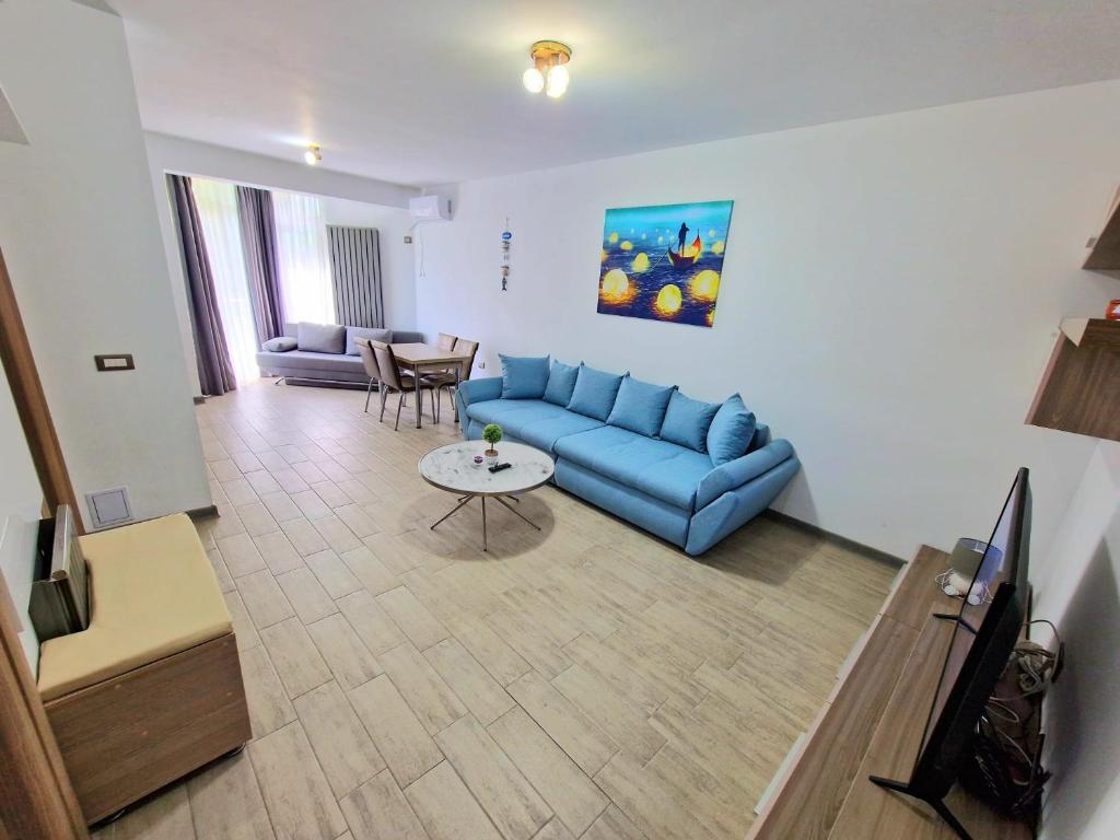 - un salon avec un canapé bleu et une table dans l'établissement Blue95, à Mamaia Nord – Năvodari